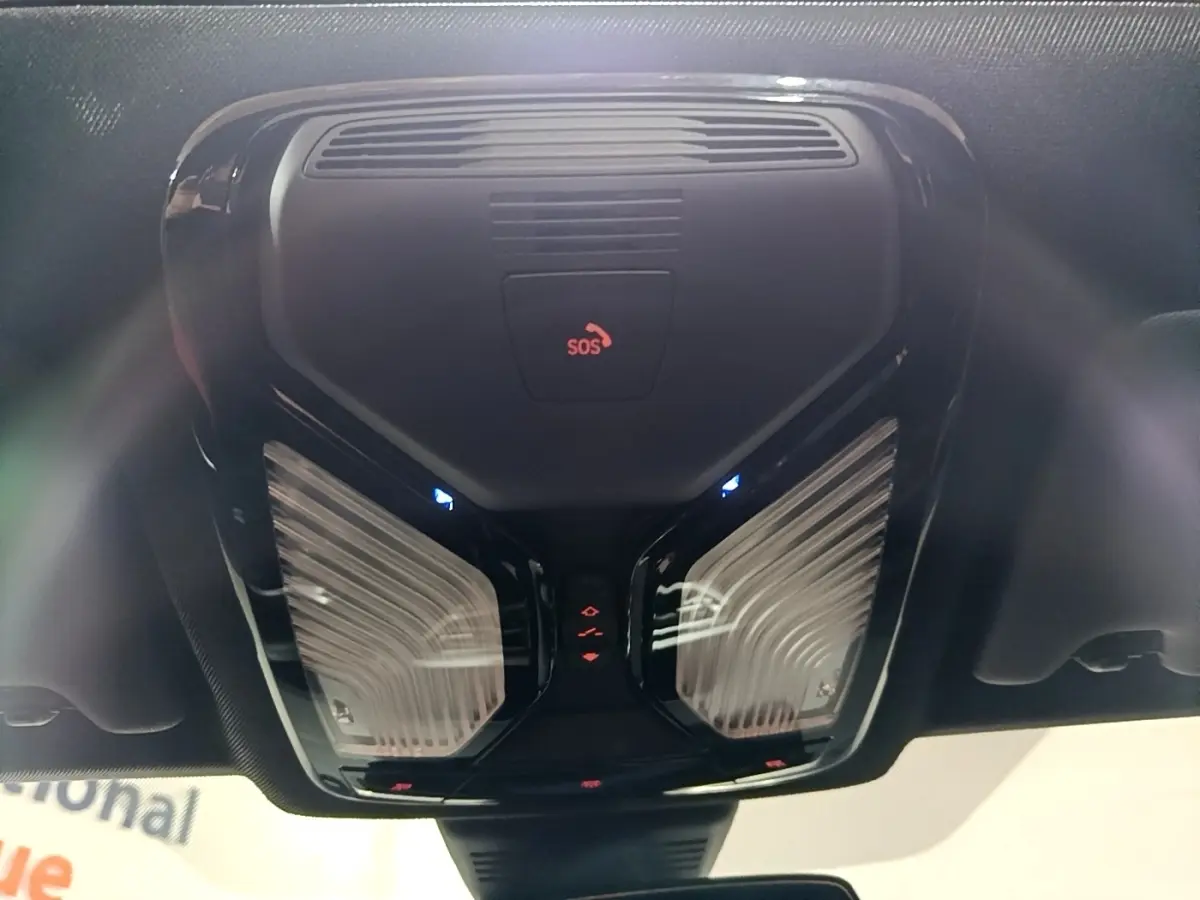 Vue en contre-plongée du plafonnier noir avec bouton SOS et éclairages LED intérieurs d'une BMW Série 3 noire 2022.