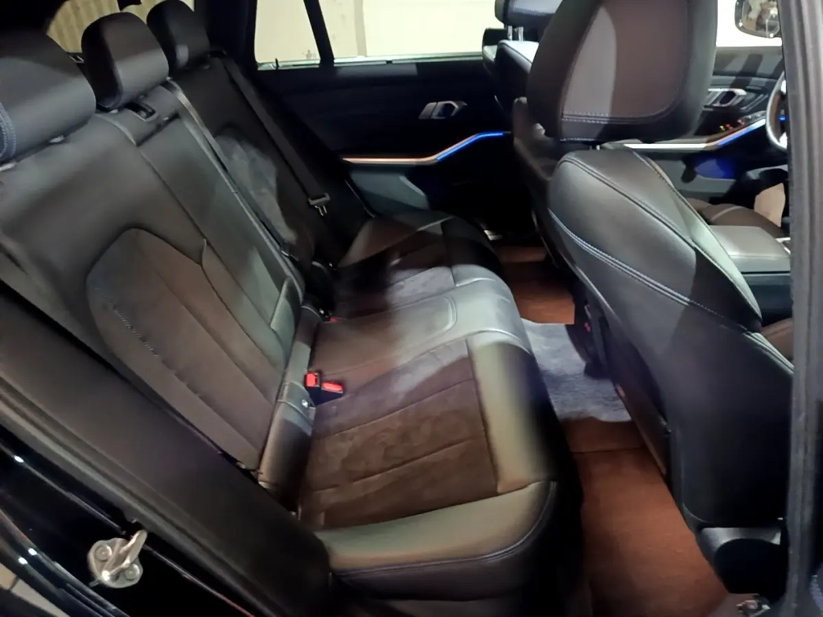 Vue intérieure côté droit sur la banquette arrière en cuir noir et alcantara de la BMW Série 3 318i M Sport 2022.