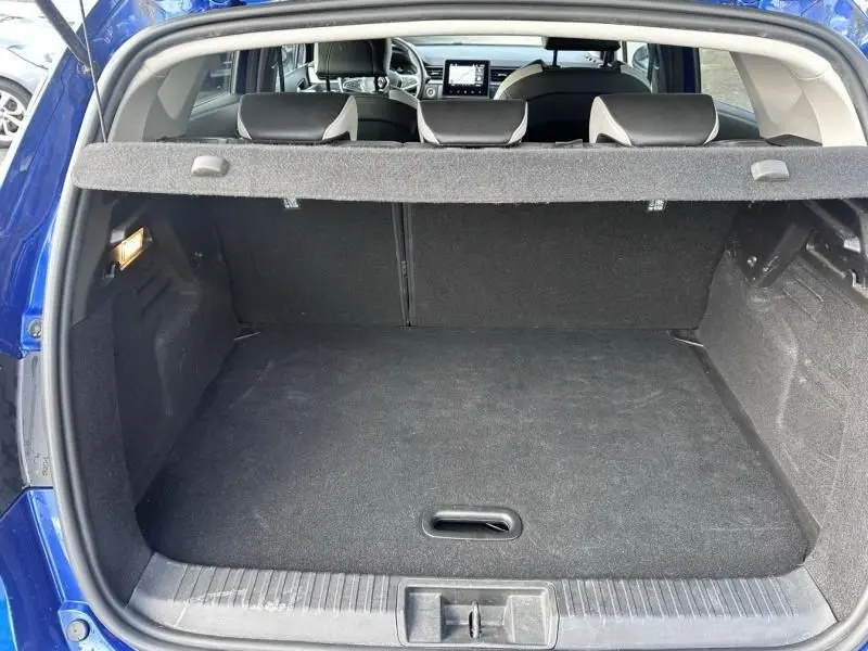 Coffre ouvert vu de l'arrière d'un Renault Captur bleu métal 2022, intérieur noir avec tablette cache-bagages.