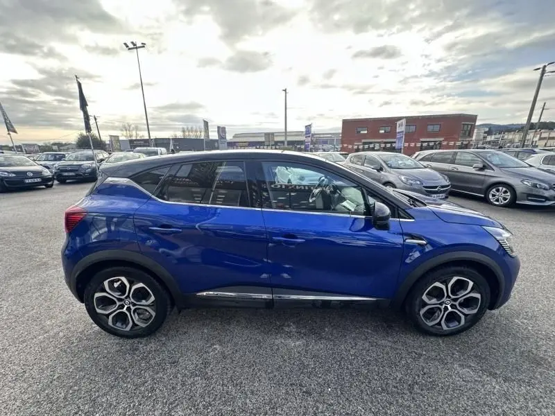 Profil côté gauche d’un Renault Captur 1.6 E Tech Hybride 145 Intense bleu métal avec jantes distinctives en alliage.