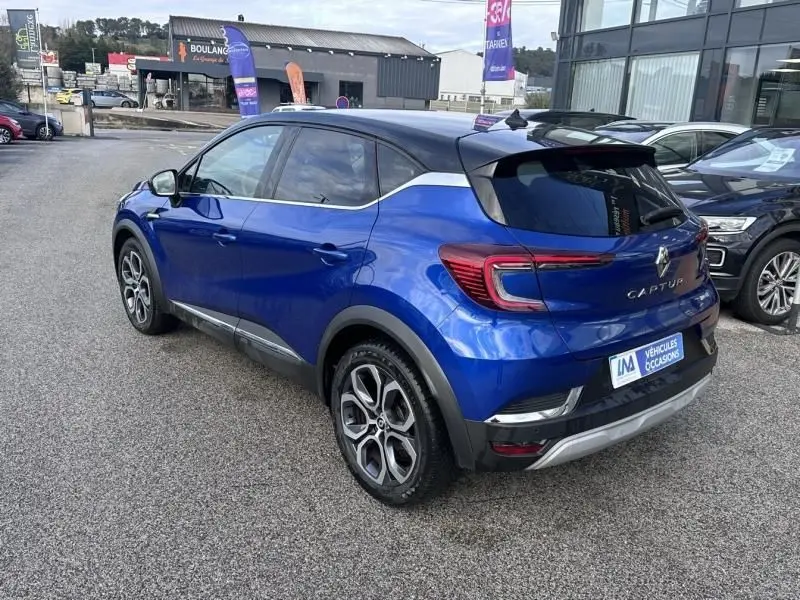 Vue 3/4 arrière droite du Renault Captur 1.6 E-Tech Hybride 145 Intense bleu métal avec toit noir et jantes alliage.