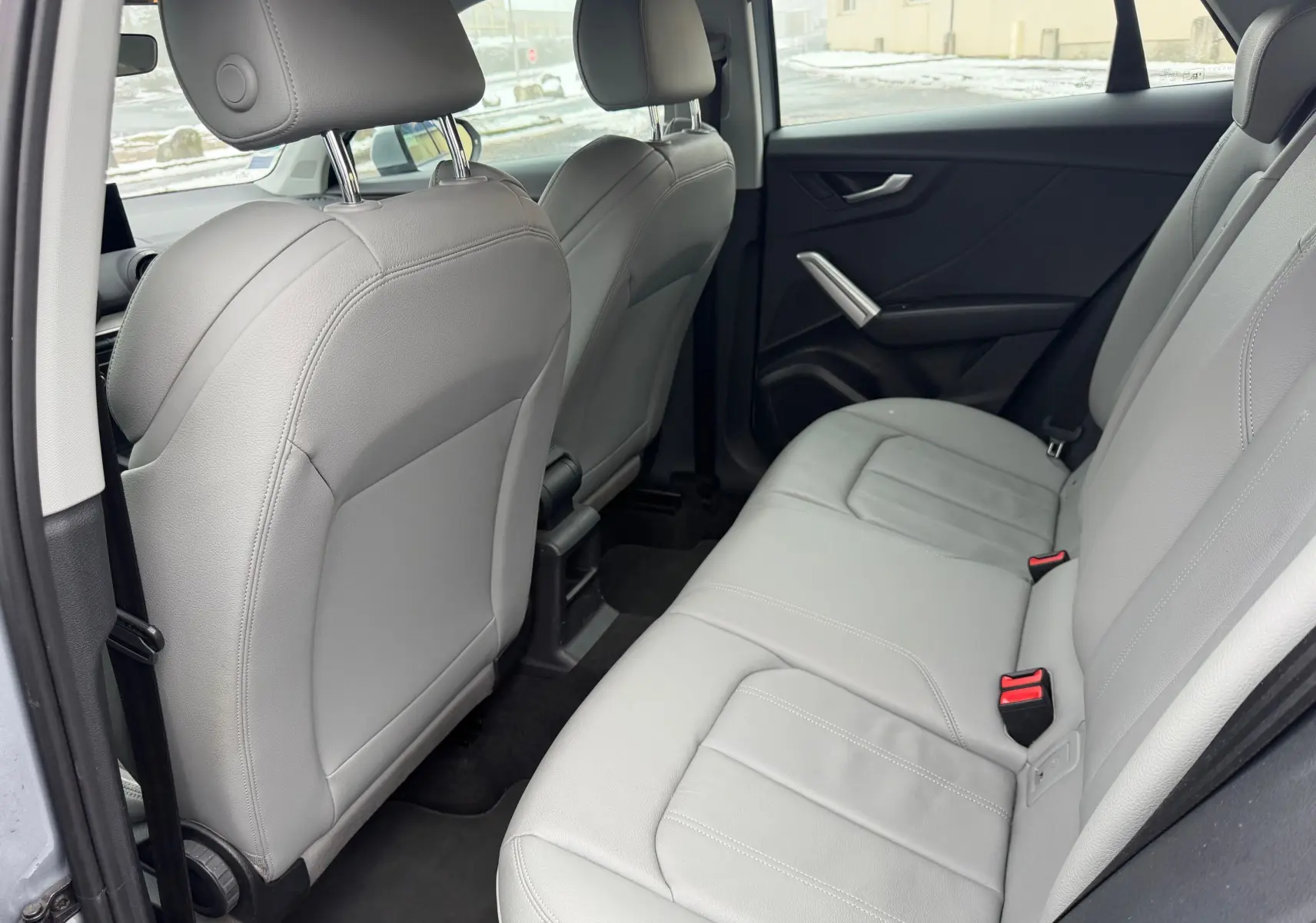 Vue intérieure côté gauche montrant la banquette arrière en similicuir gris clair de l'Audi Q2 2017.