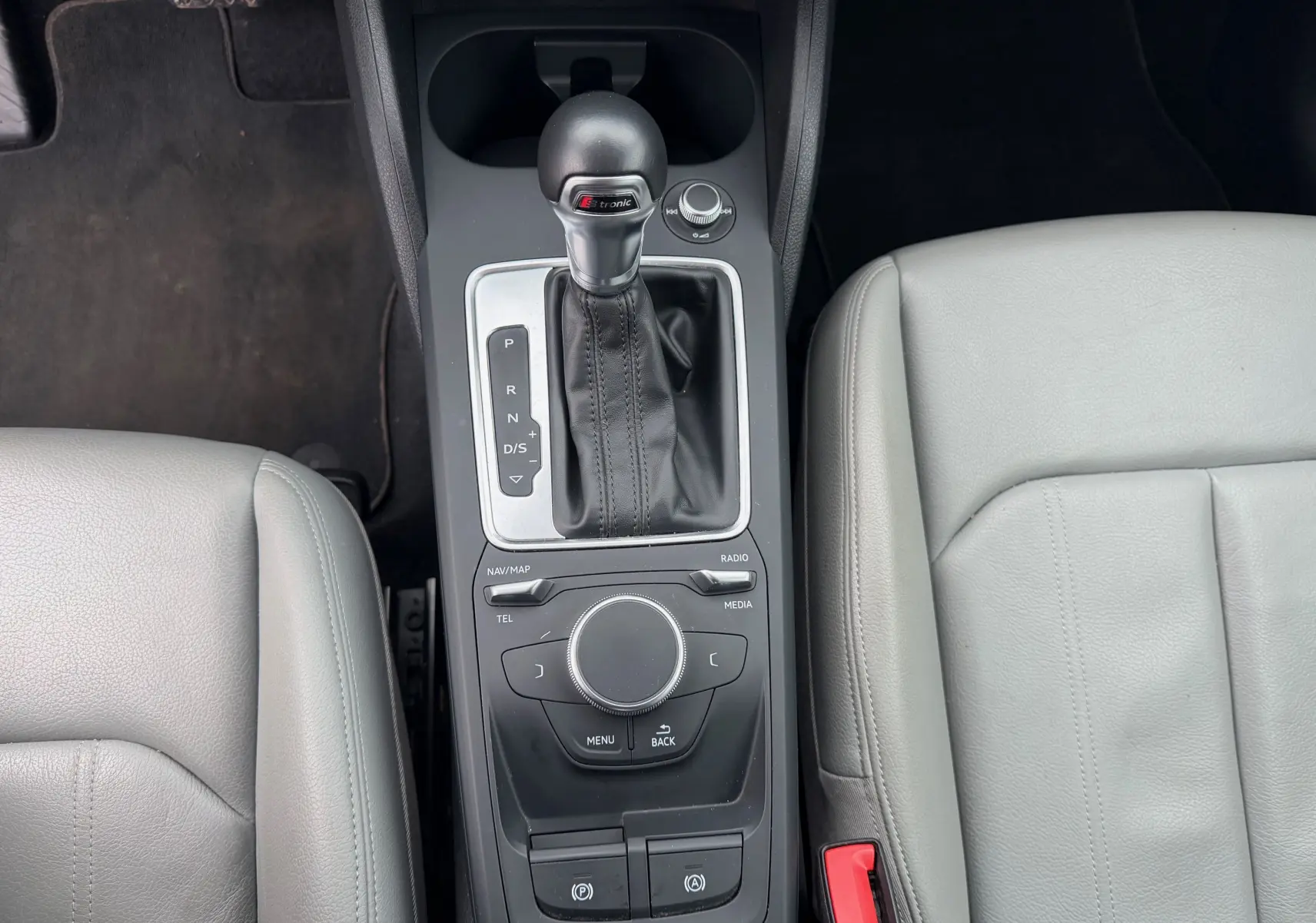 Vue plongeante sur la console centrale de l'Audi Q2 2017, avec levier de vitesse S-Tronic et sellerie gris clair en similicuir.