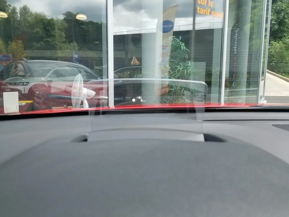 Vue intérieure du tableau de bord du Hyundai Kona rouge 2023, avec affichage tête haute transparent en avant.
