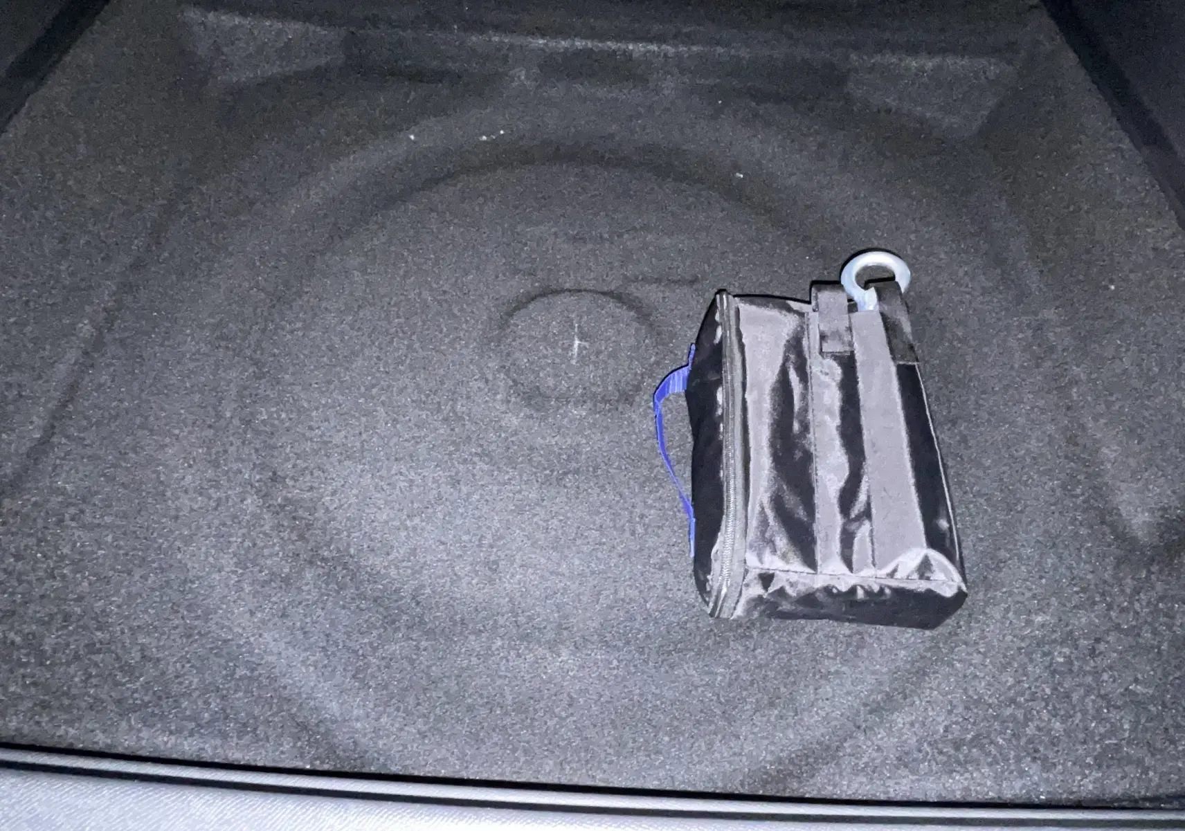Vue intérieure du coffre du Peugeot 3008 noir, montrant un sac de rangement noir posé au centre.