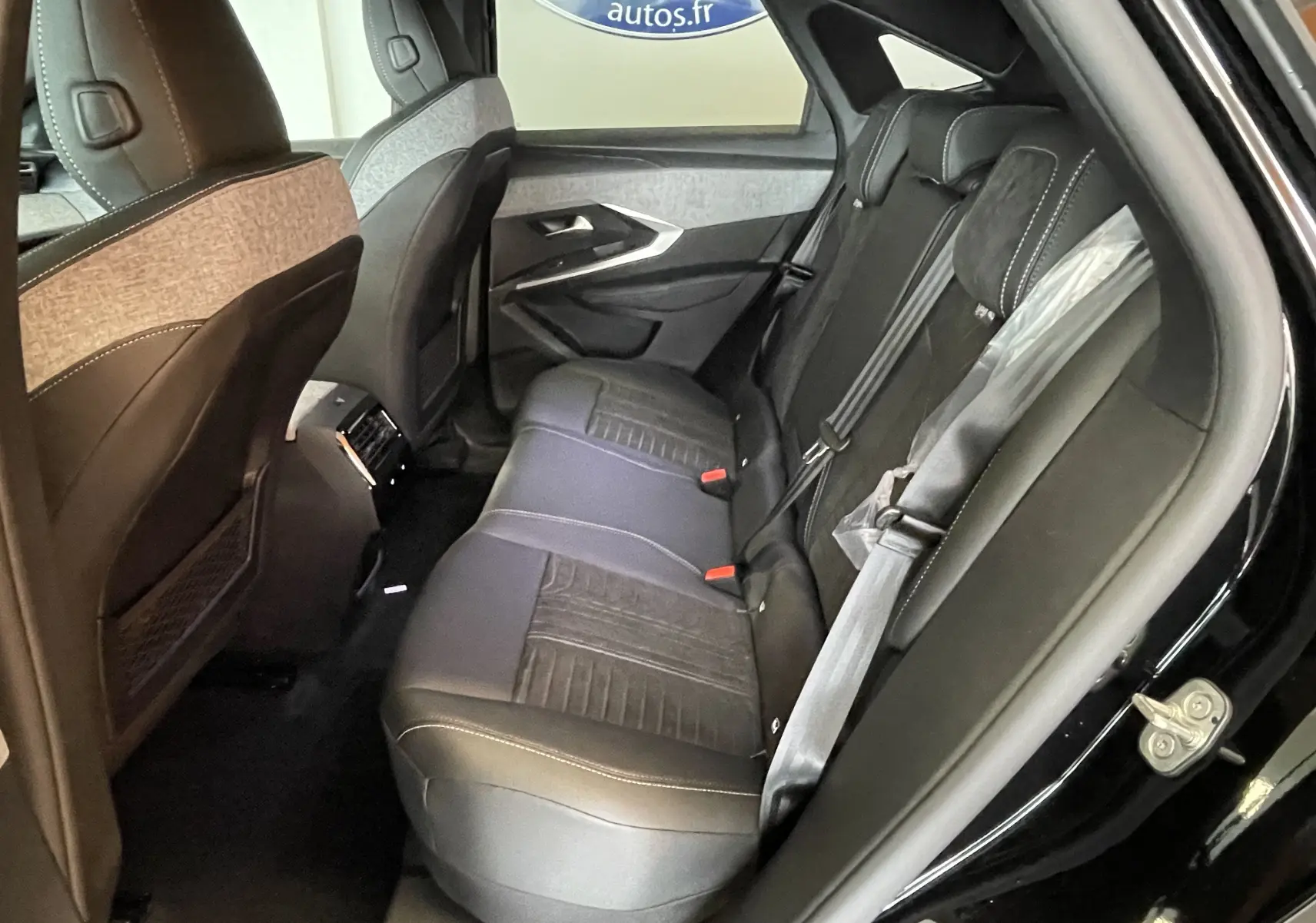 Vue côté droit des sièges arrière noirs en Alcantara du Peugeot 3008 Hybrid 145 GT Exclusive 2026 avec porte ouverte.