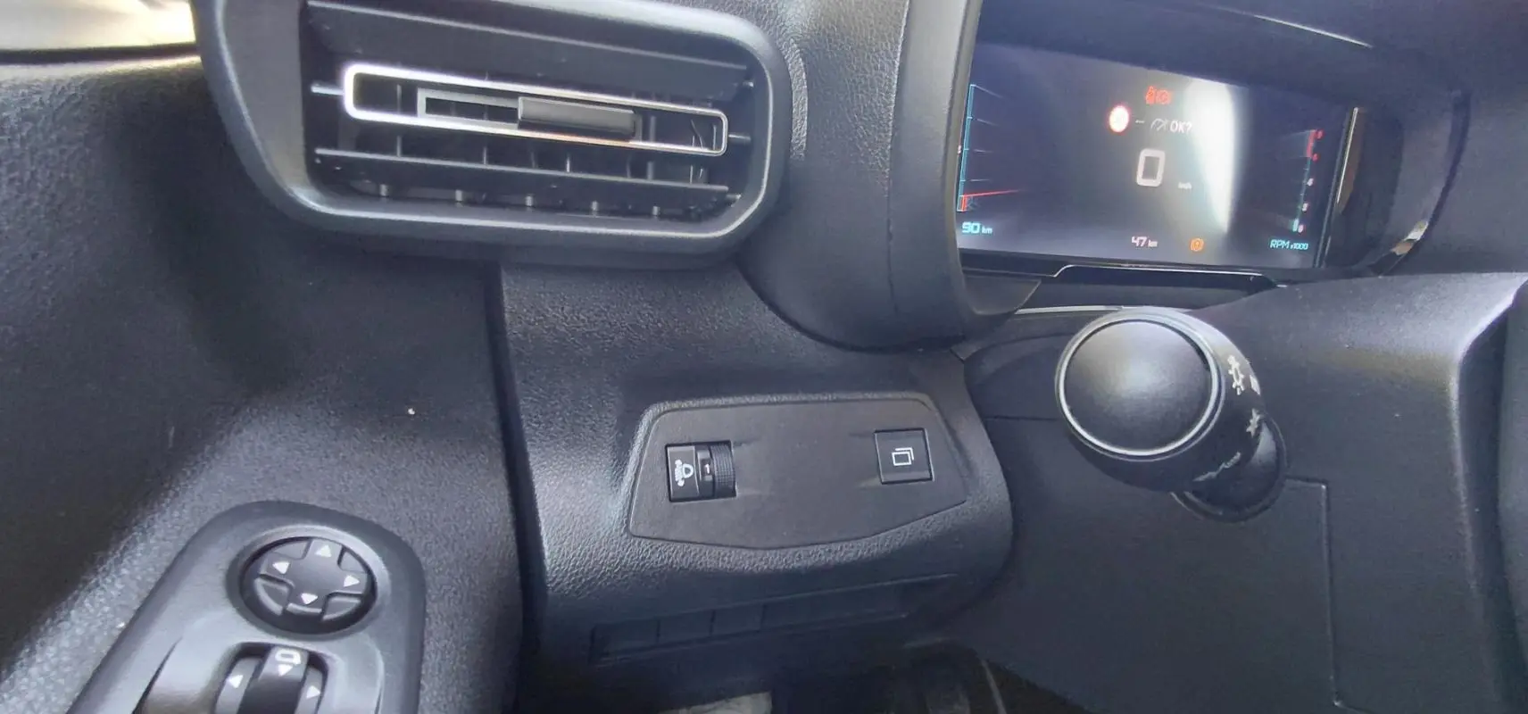 Vue rapprochée de l'intérieur du tableau de bord du Citroën Berlingo 2025, avec commandes et écran digital.