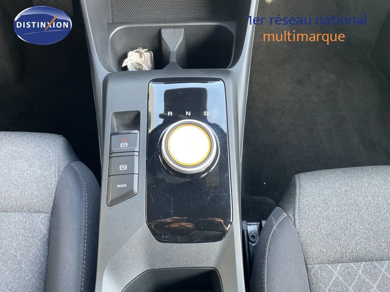 Vue plongeante sur la console centrale de la MG3 2024, avec sélecteur rotatif de boîte auto et sièges tissu gris.