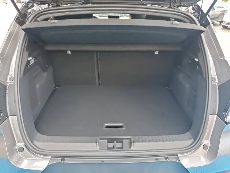 Coffre ouvert vu de l'arrière du Renault Captur gris Cassiopée 2025, espace de rangement spacieux et plancher plat.