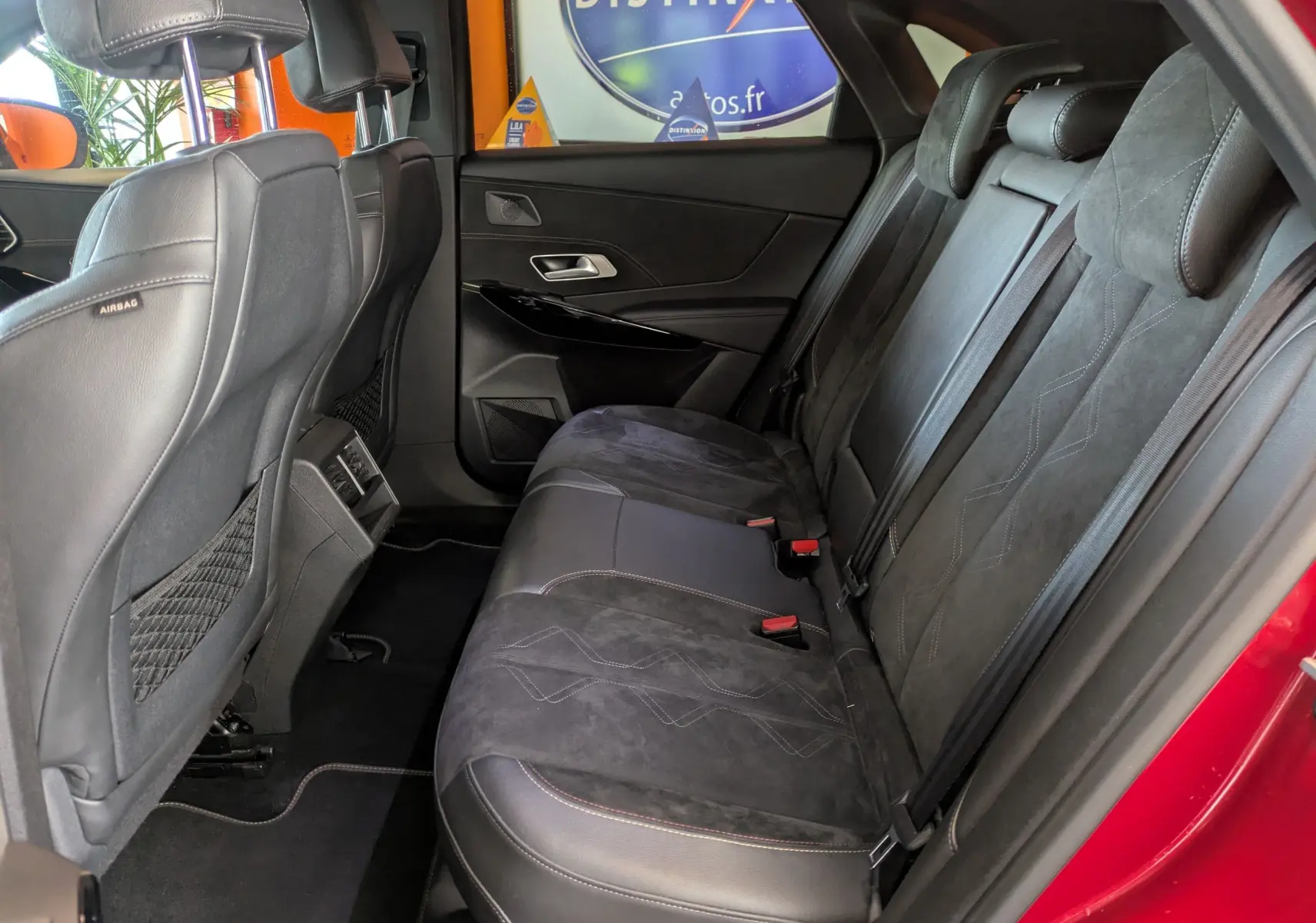 Vue intérieure côté droit des sièges arrière en cuir noir du DS7 rouge 2019, avec finitions élégantes et appuie-têtes intégrés.