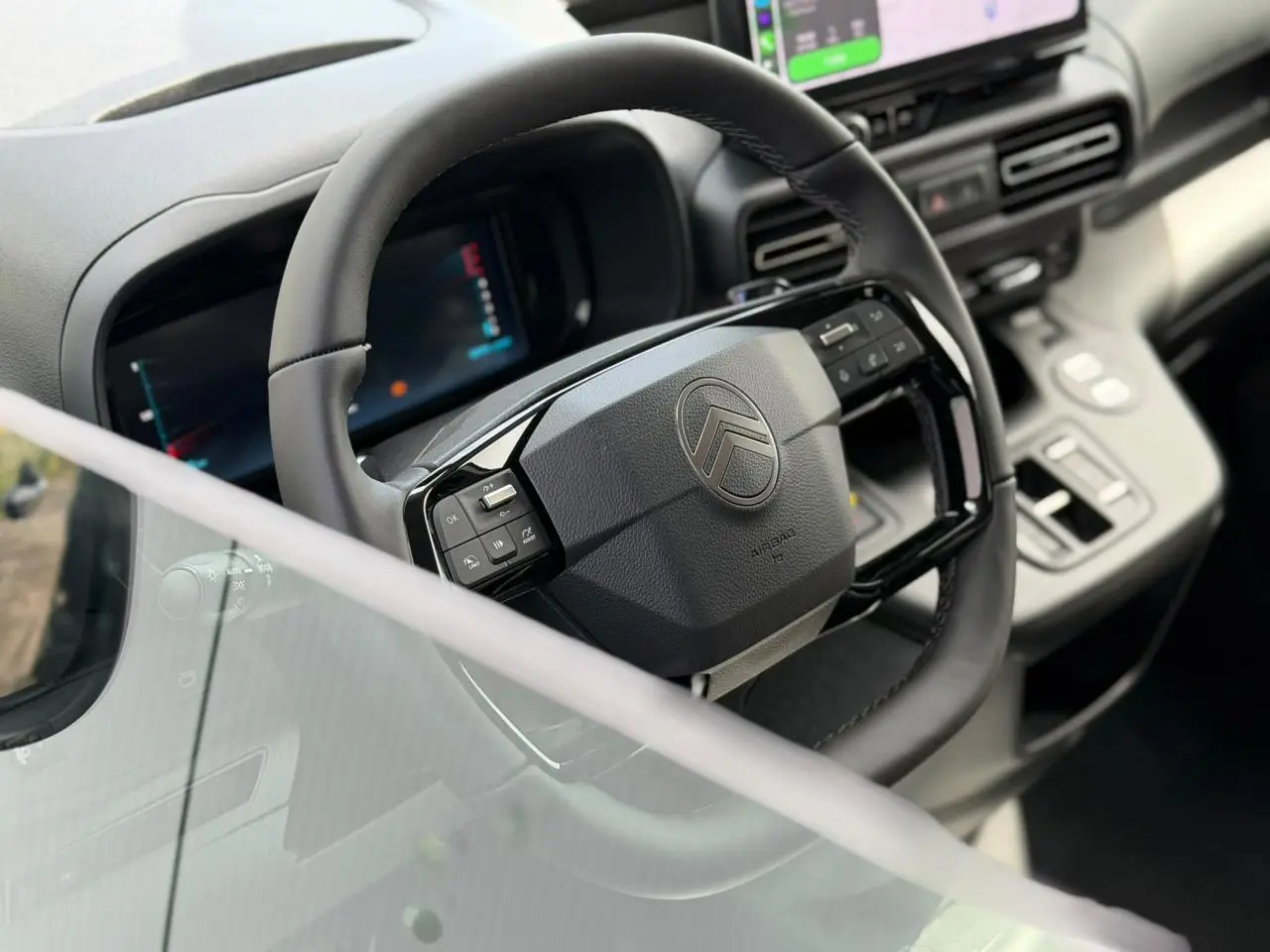 Vue rapprochée du volant cuir multifonctions et du combiné numérique du tableau de bord intérieur du Citroën Berlingo Multispace 2026.