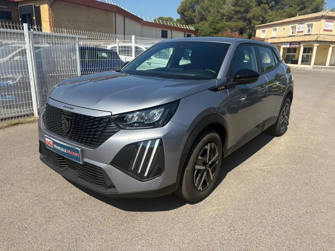 Peugeot 2008 Hybrid gris en 3/4 avant droit, avec calandre noire et jantes 16 pouces visibles.