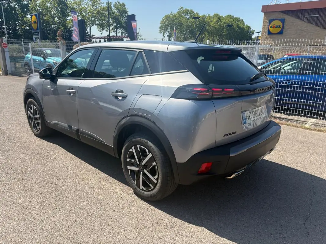 Peugeot 2008 Hybrid 145 gris en 3/4 arrière droit, jantes 16 pouces et feux arrière LED distinctifs.
