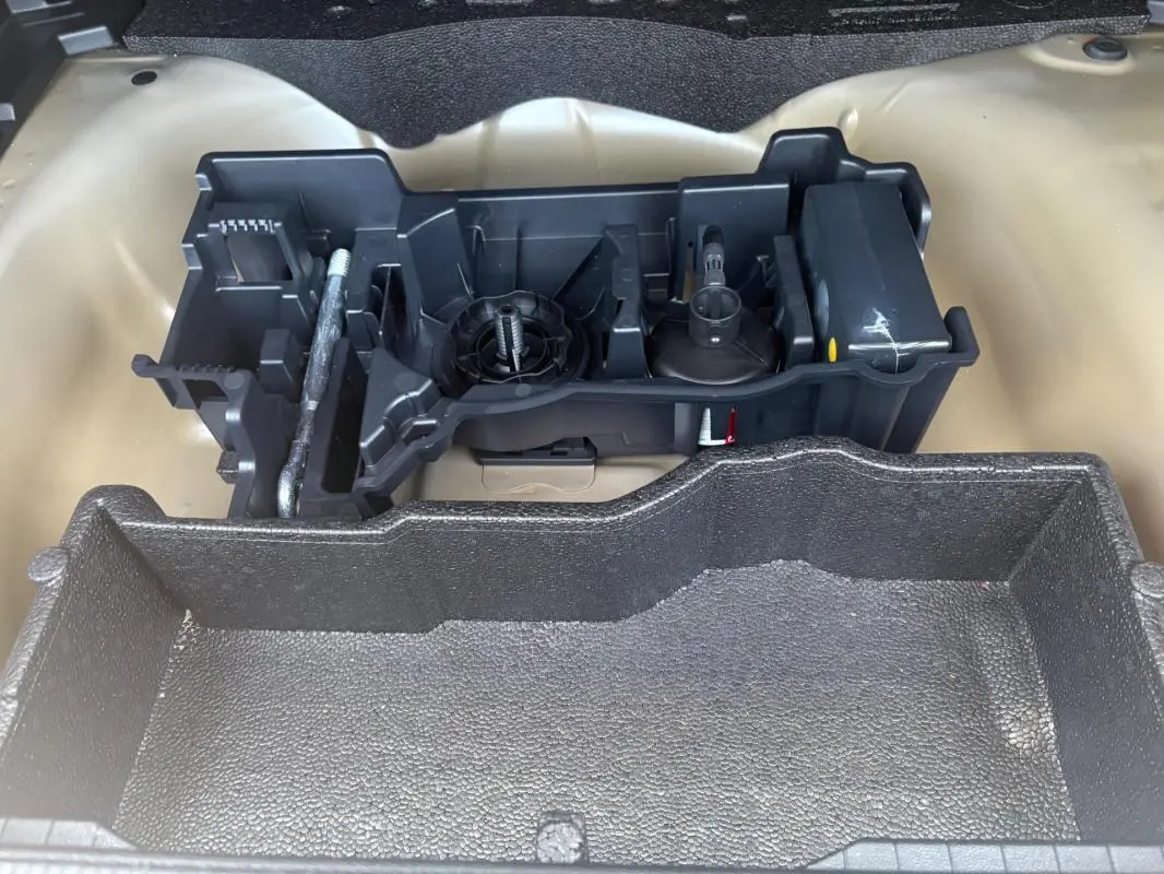 Vue rapprochée de l'espace de rangement gris sous le plancher du coffre du Peugeot 2008 Hybrid 145 e-DCS6 Style 2025.