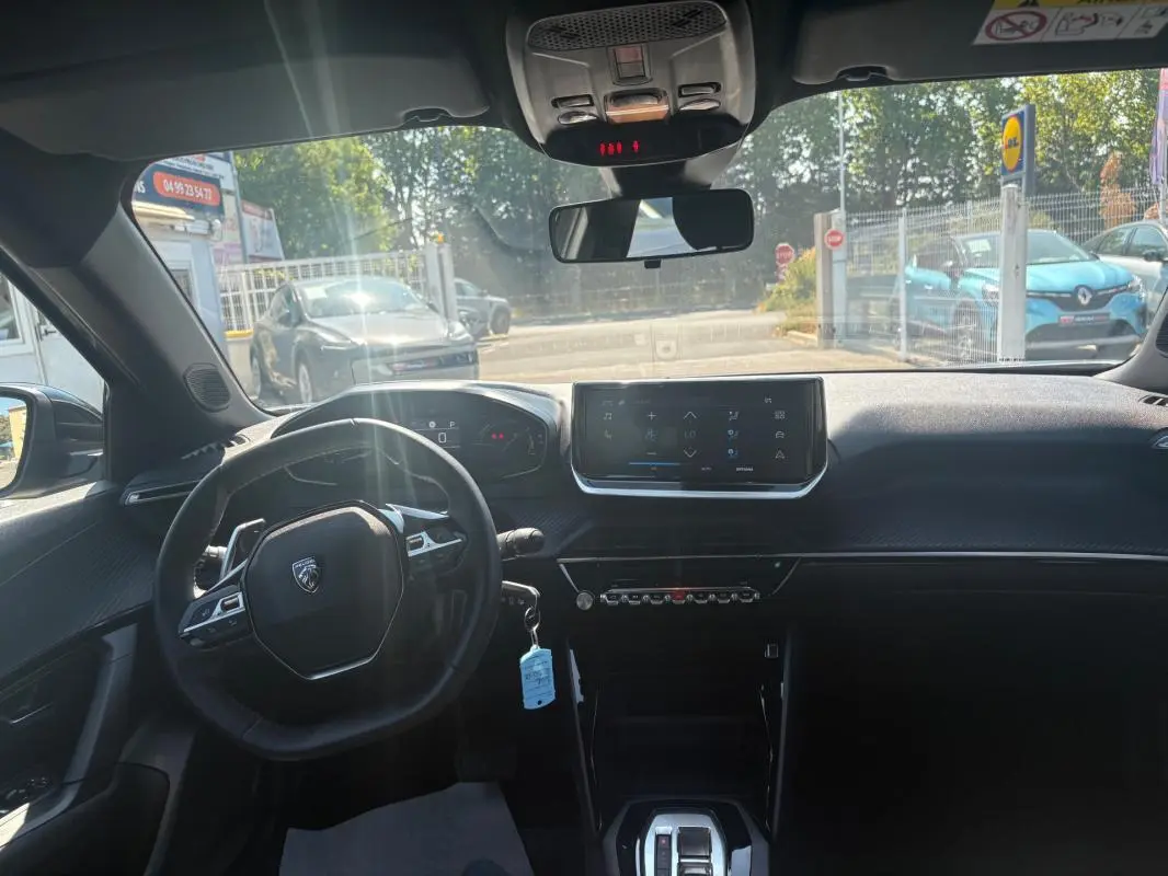 Vue intérieure avant du Peugeot 2008 Hybrid 145 Style gris 2025 avec écran tactile et cockpit numérique.