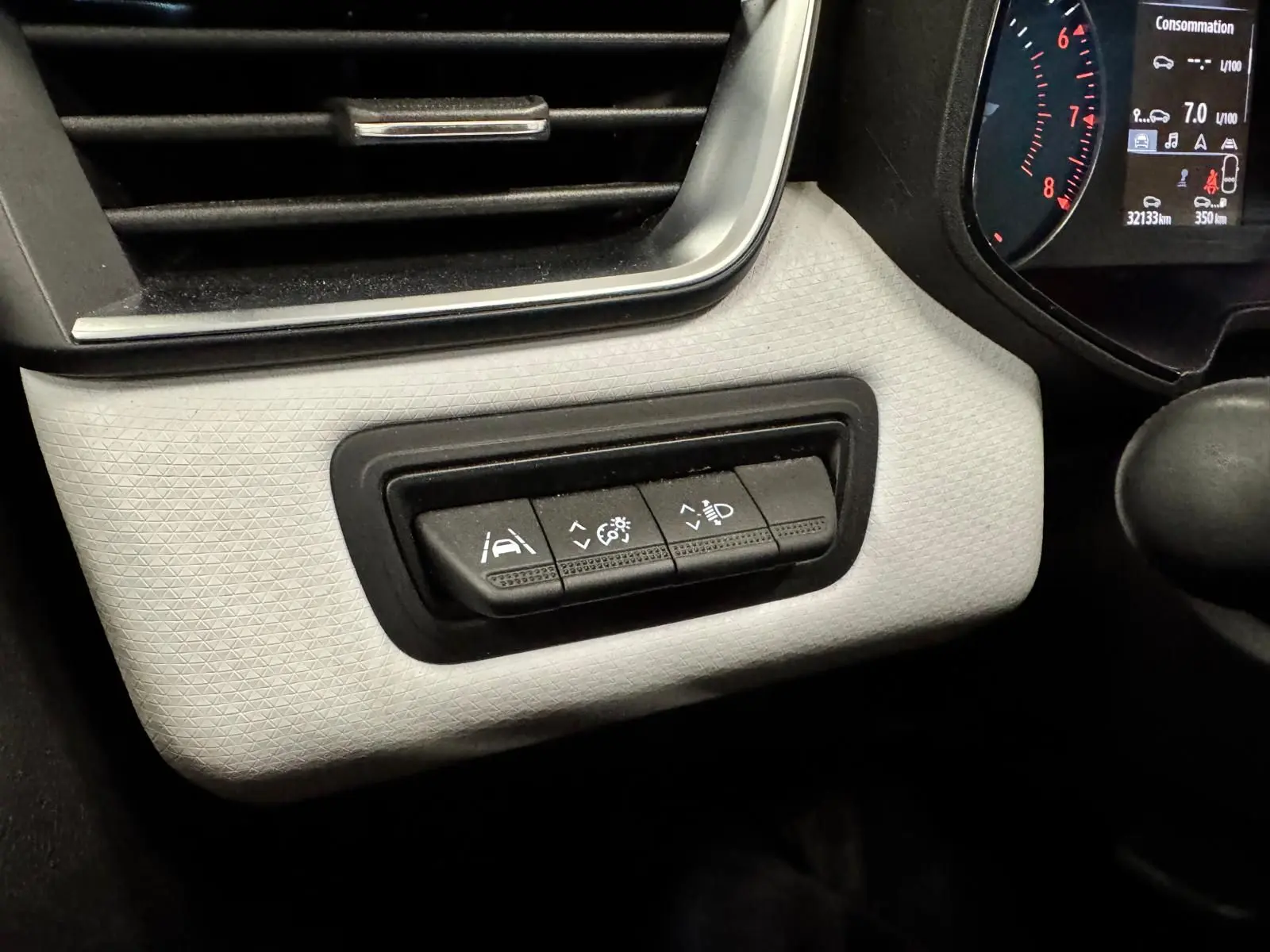 Vue intérieure du tableau de bord côté gauche de la Renault Clio V gris aluminium, avec commandes d'aide à la conduite et éclairage.
