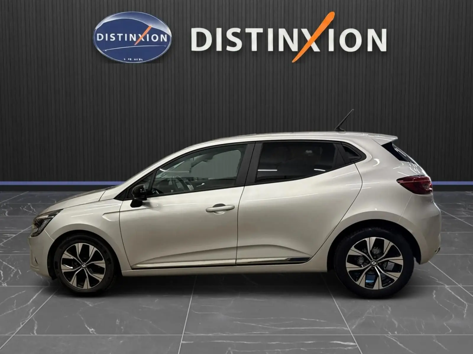 Profil droit d'une Renault Clio V gris aluminium 2022 avec jantes alliage bicolores et vitres teintées.