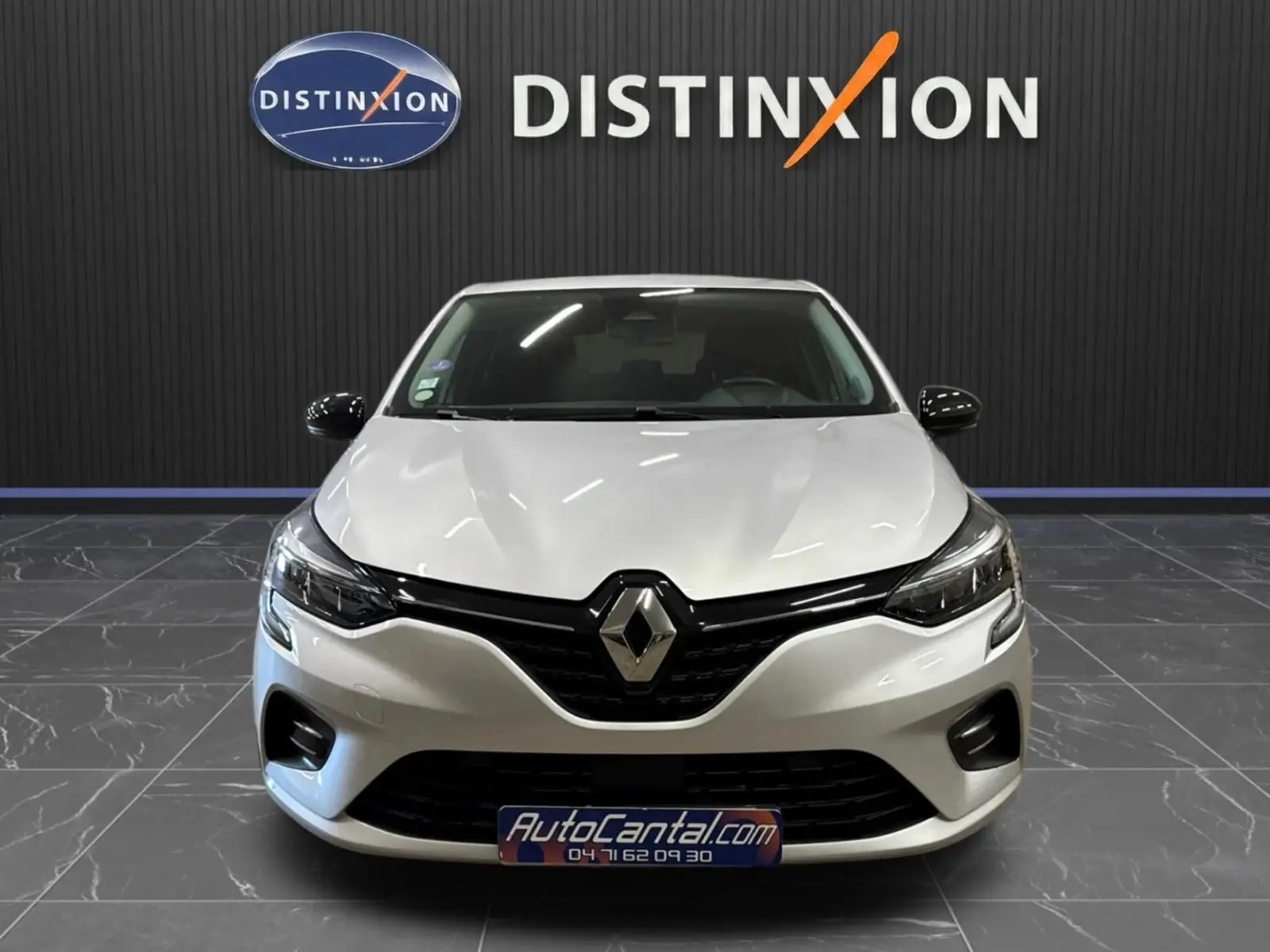 Vue avant d'une Renault Clio V gris aluminium, avec calandre noire brillante et phares LED, en showroom Distinxion.