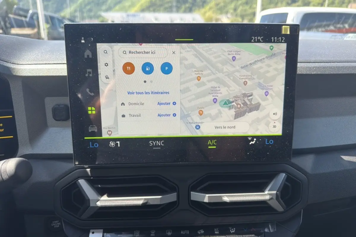 Écran tactile central du tableau de bord du Dacia Bigster Hybrid 150, affichant la navigation GPS en vue rapprochée.