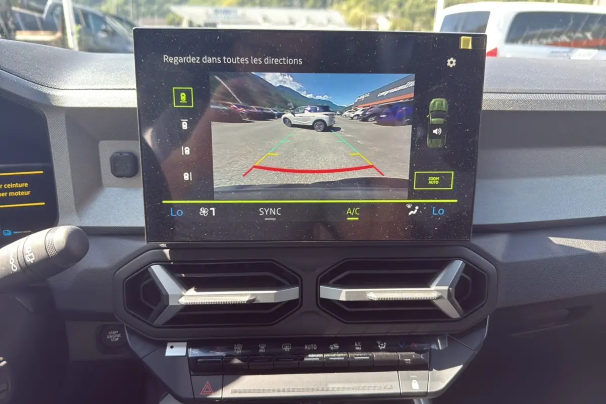 Vue intérieure du tableau de bord du Dacia Bigster gris schiste, avec écran central affichant la caméra multiview de recul.