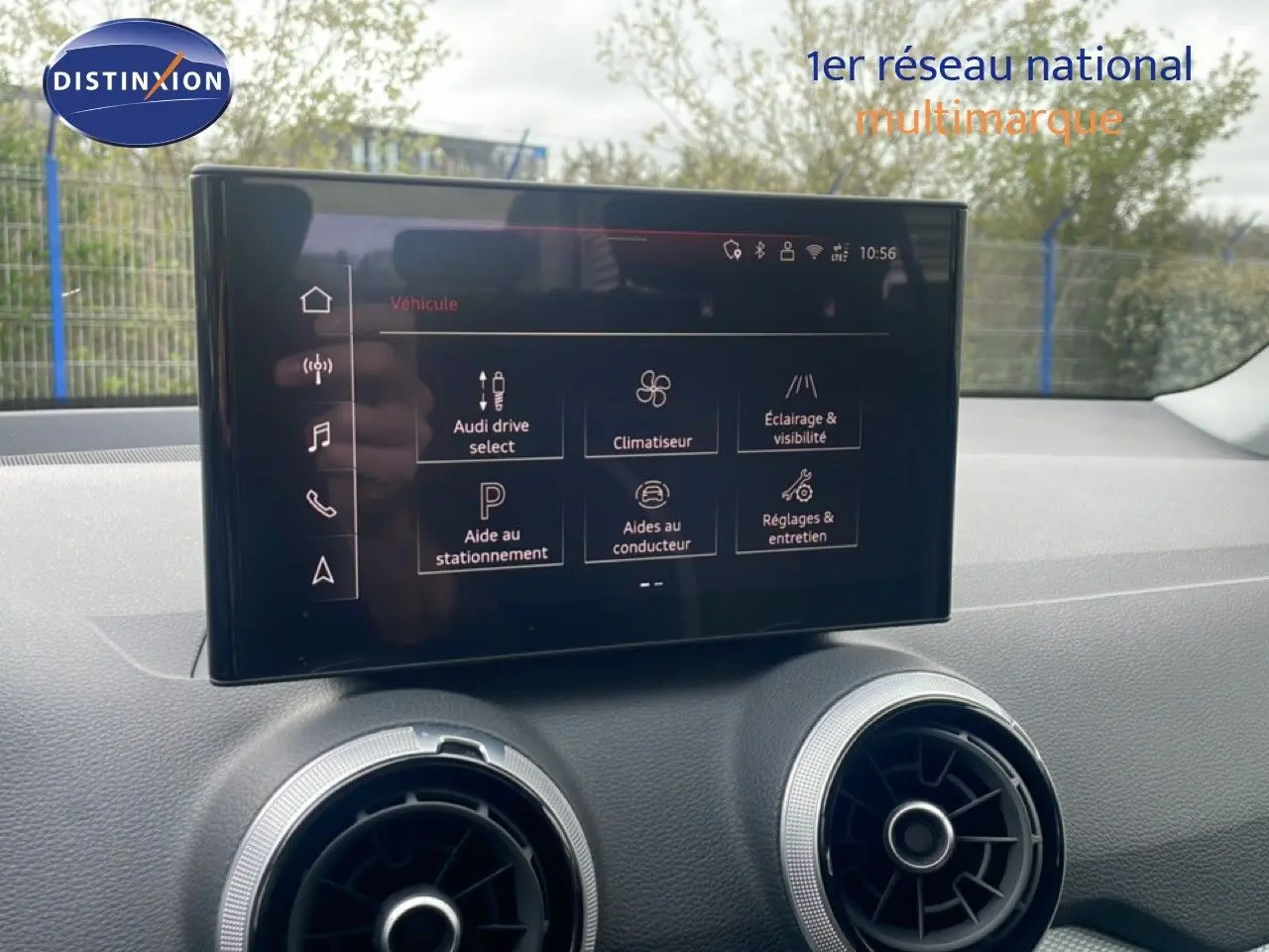 Écran tactile central affichant les options du véhicule dans l’habitacle d’un Audi Q2 noir mito metal, vue intérieure frontale.