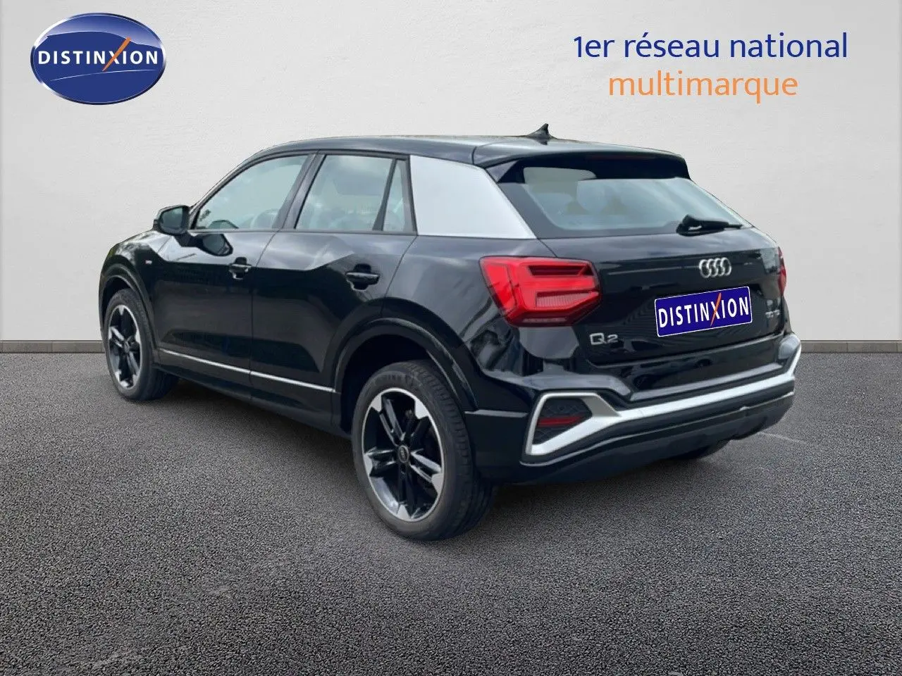 Audi Q2 noir mito metal vue 3/4 arrière droit, avec jantes noires et détails S-Line visibles.