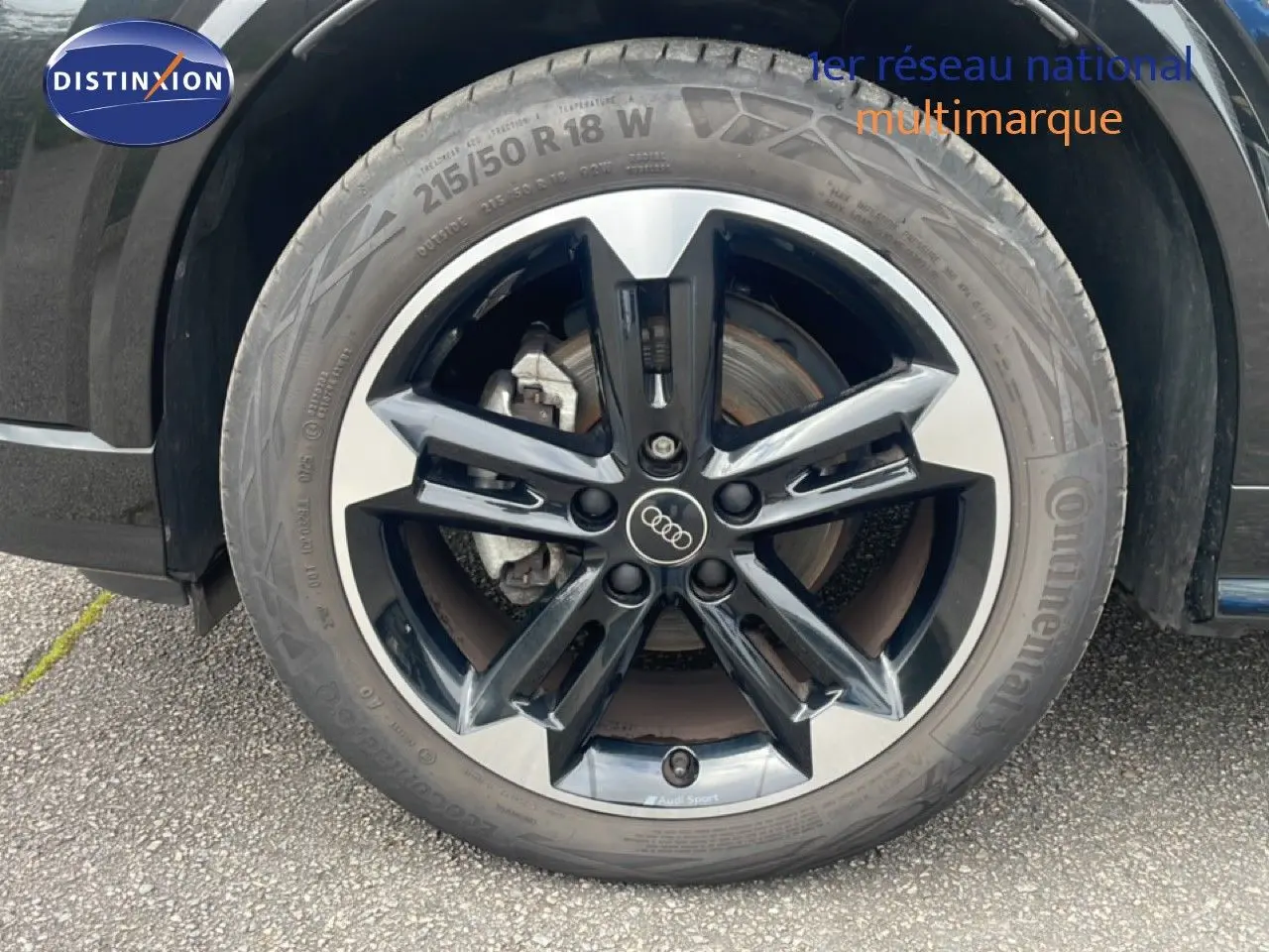 Gros plan sur la jante noire et argentée Audi Sport de l'Audi Q2 30 TDI S-Line noir mito metal, avec pneu Continental.