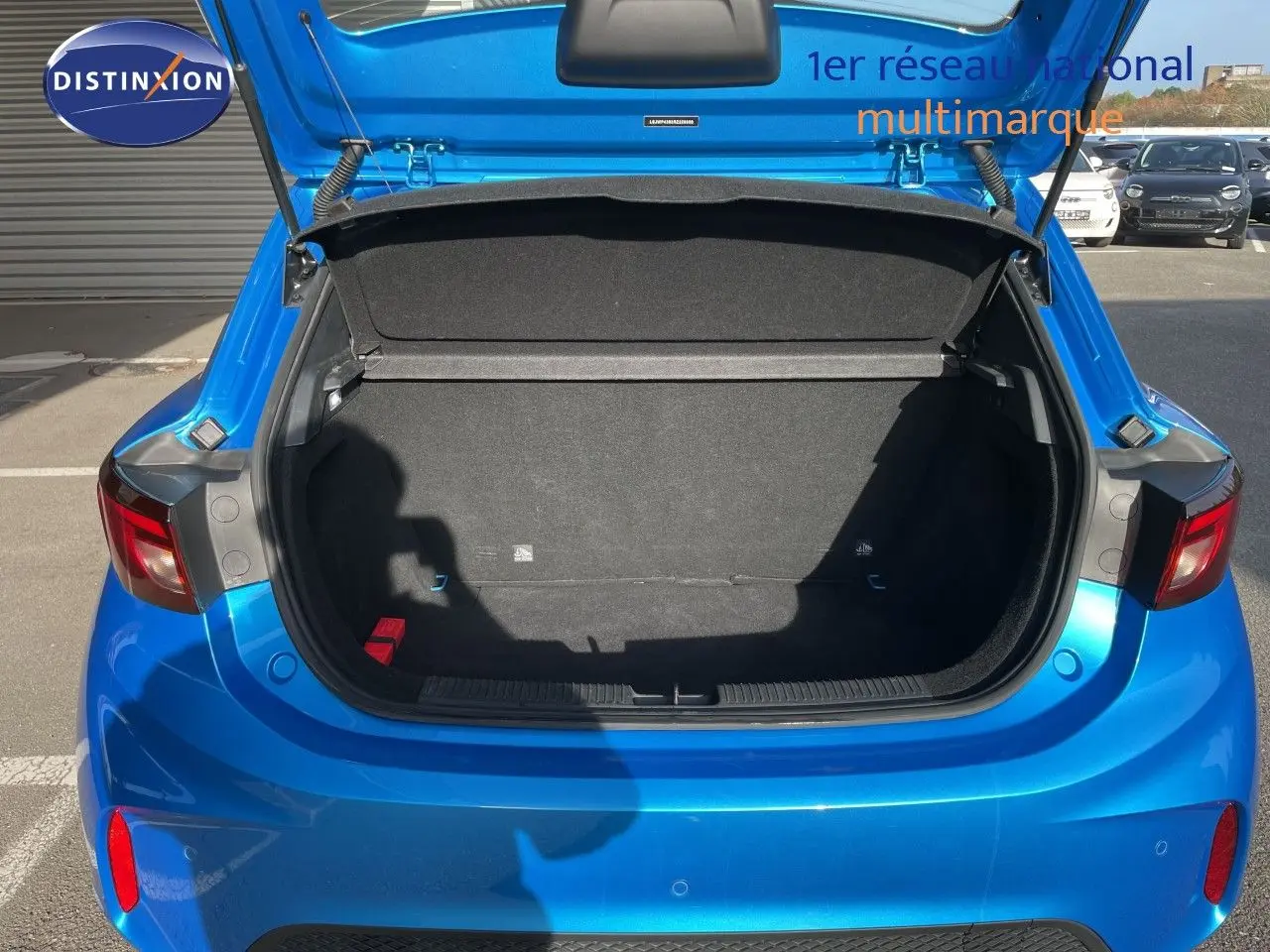 Coffre ouvert vu de l'arrière d'une MG3 1.5L HYBRID+ 195CH en bleu Como Metal, avec intérieur de coffre noir.