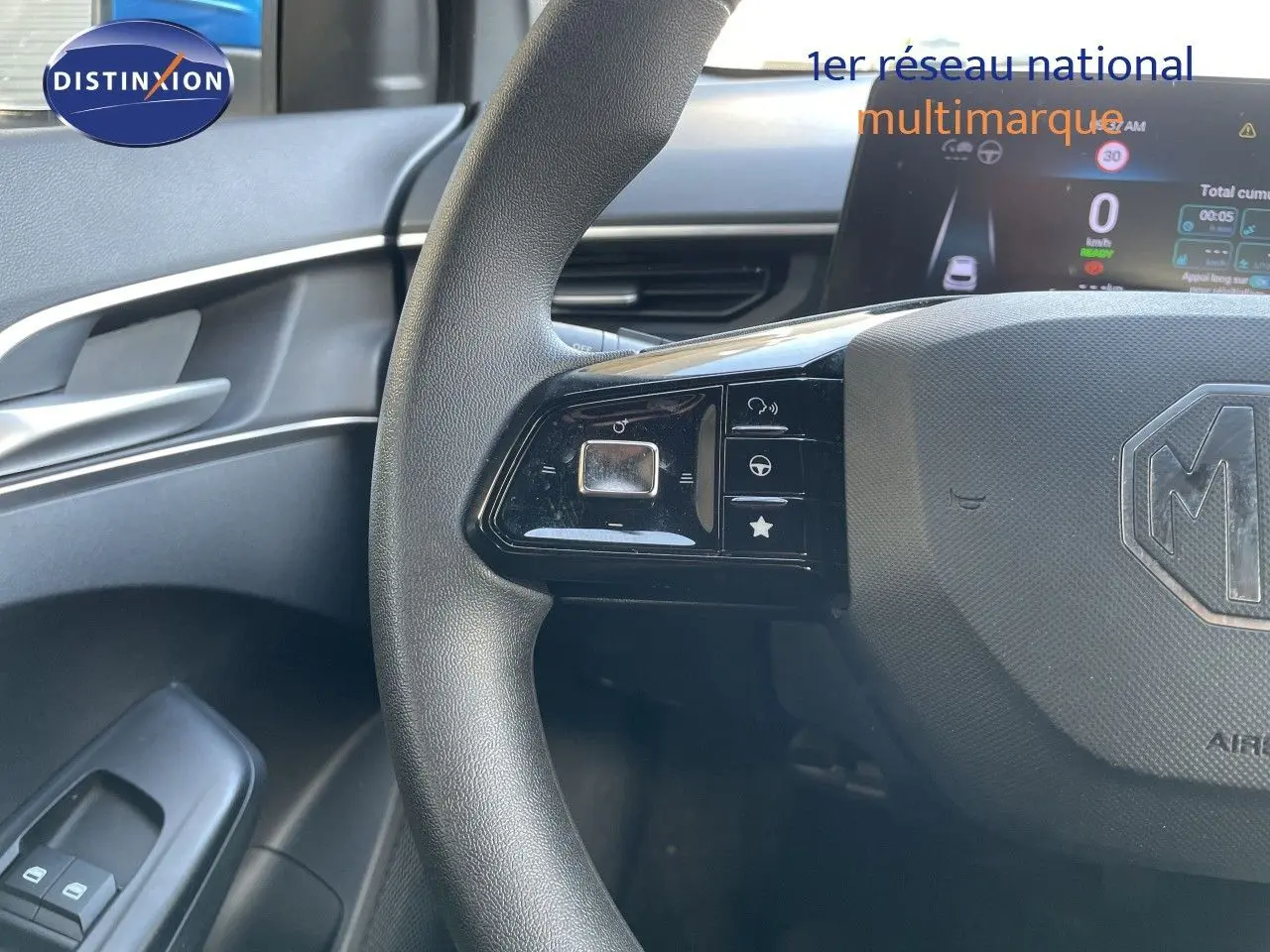 Gros plan sur le volant noir de la MG3 2024, version 1.5L Hybrid+, avec commandes intégrées et tableau de bord numérique visible.