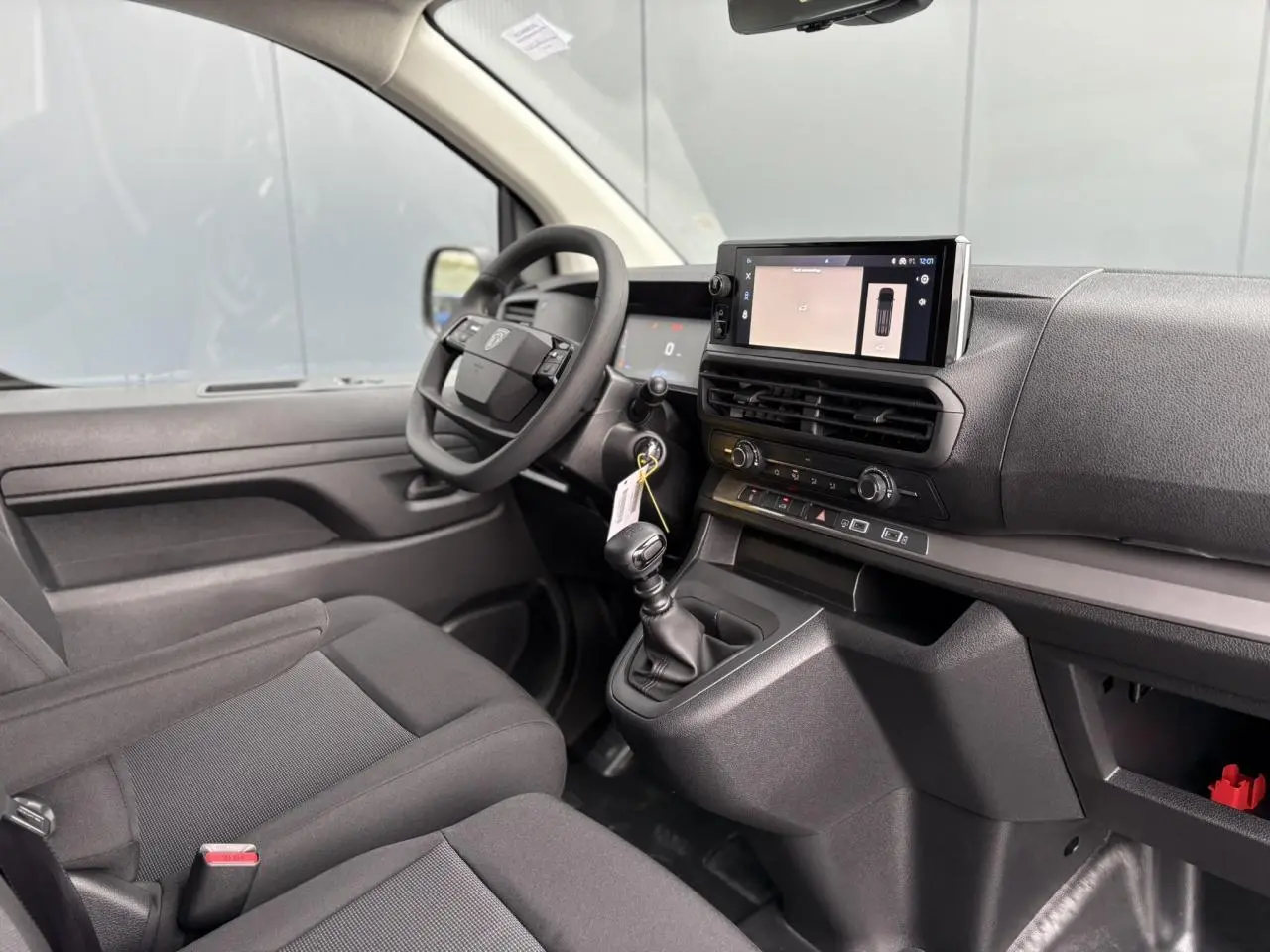 Intérieur du Peugeot Expert Fourgon 2025 vu côté conducteur, avec tableau de bord noir et écran tactile 10 pouces.