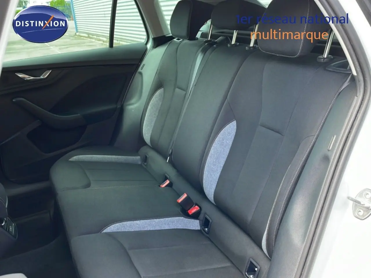 Vue intérieure côté droit sur la banquette arrière en tissu gris et noir du Skoda Scala blanc glacier 2025.