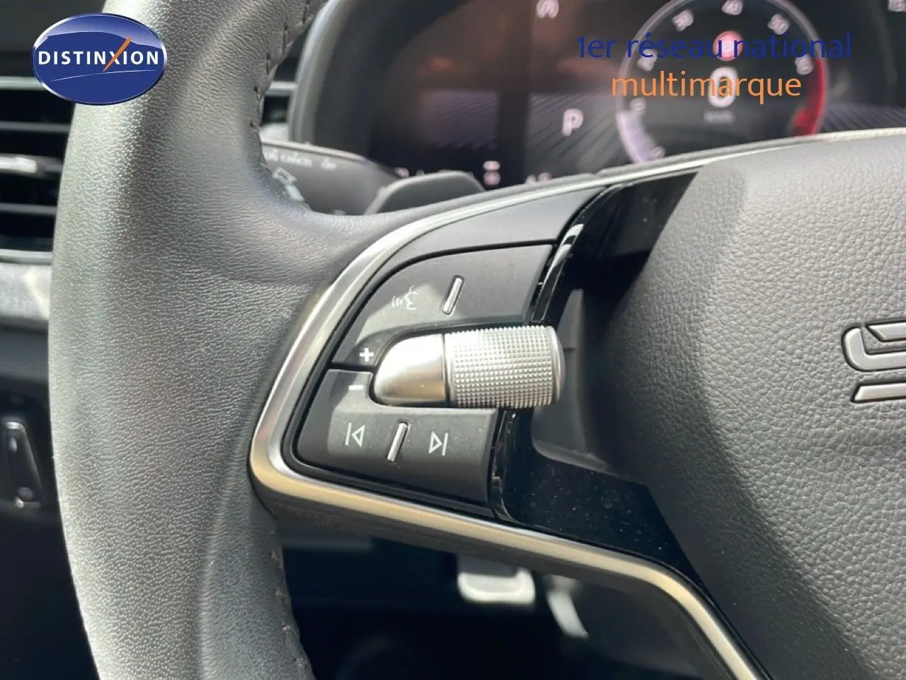 Gros plan sur la partie gauche du volant gris noir de la Skoda Scala 2025 avec commandes multimédia intégrées.