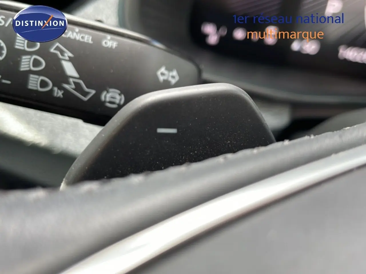Gros plan sur la palette de changement de vitesse côté droit du volant d’une Skoda Scala blanc glacier, intérieur gris noir.