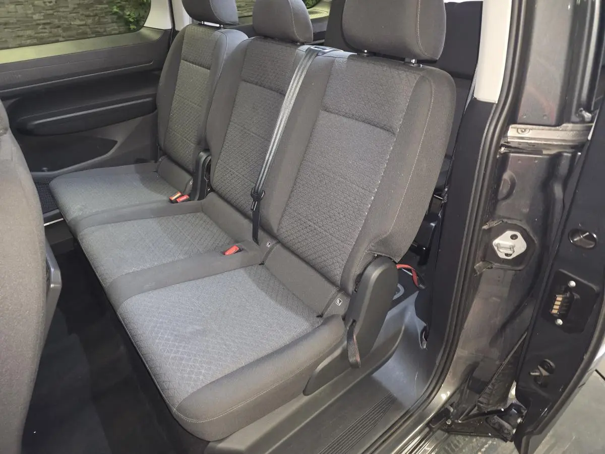 Vue intérieure côté droit sur la banquette arrière grise du Ford Transit Connect Tourneo 2023 avec porte coulissante ouverte.