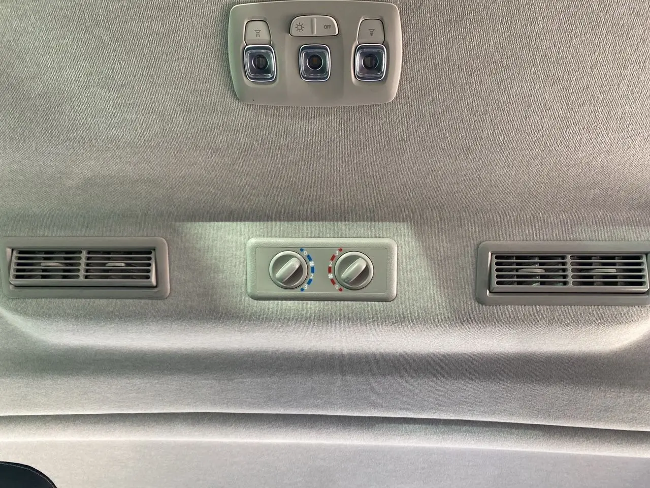Plafond intérieur gris avec commandes de climatisation arrière et éclairage dans un Renault Trafic Combi gris Highland 2025.