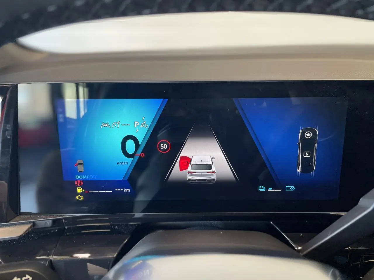 Tableau de bord numérique du Renault Rafale 2025 affichant la vitesse et l'aide au stationnement en vue frontale.