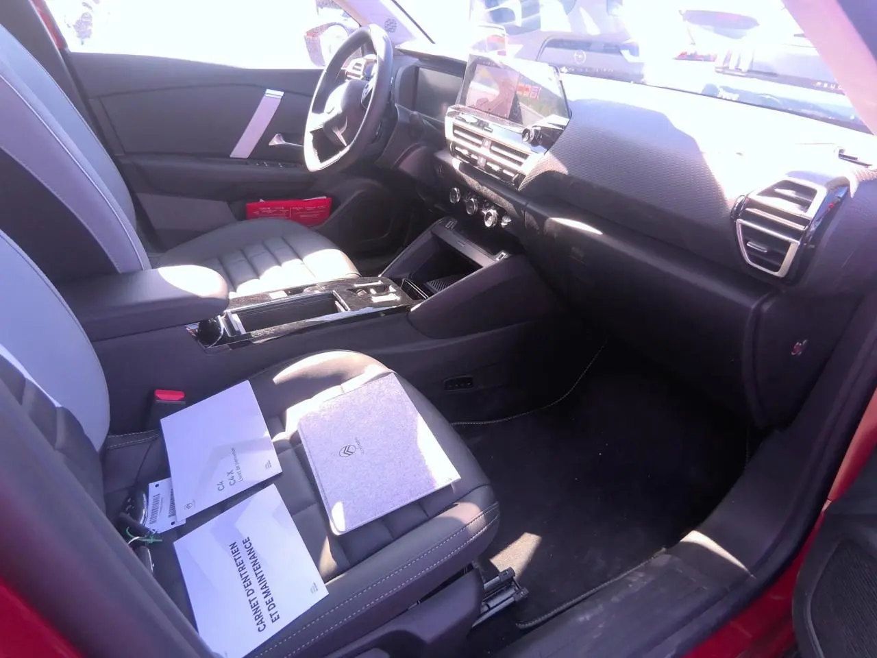 Intérieur avant droit du Citroën C4 Hybrid 2025, sièges gris, tableau de bord noir avec écran tactile central.