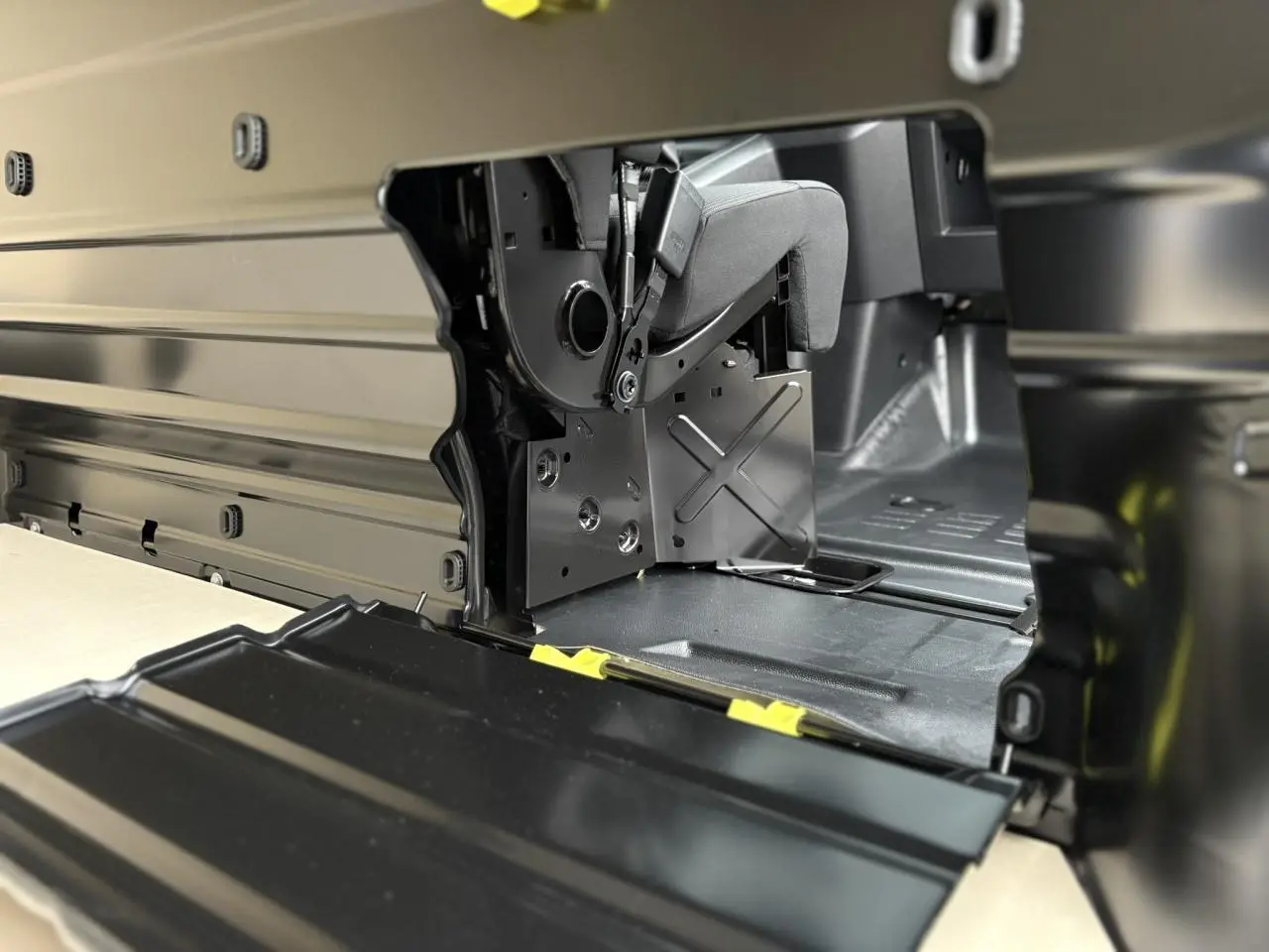 Détail intérieur du compartiment de chargement du Peugeot Expert Fourgon blanc, montrant la banquette passager relevée.