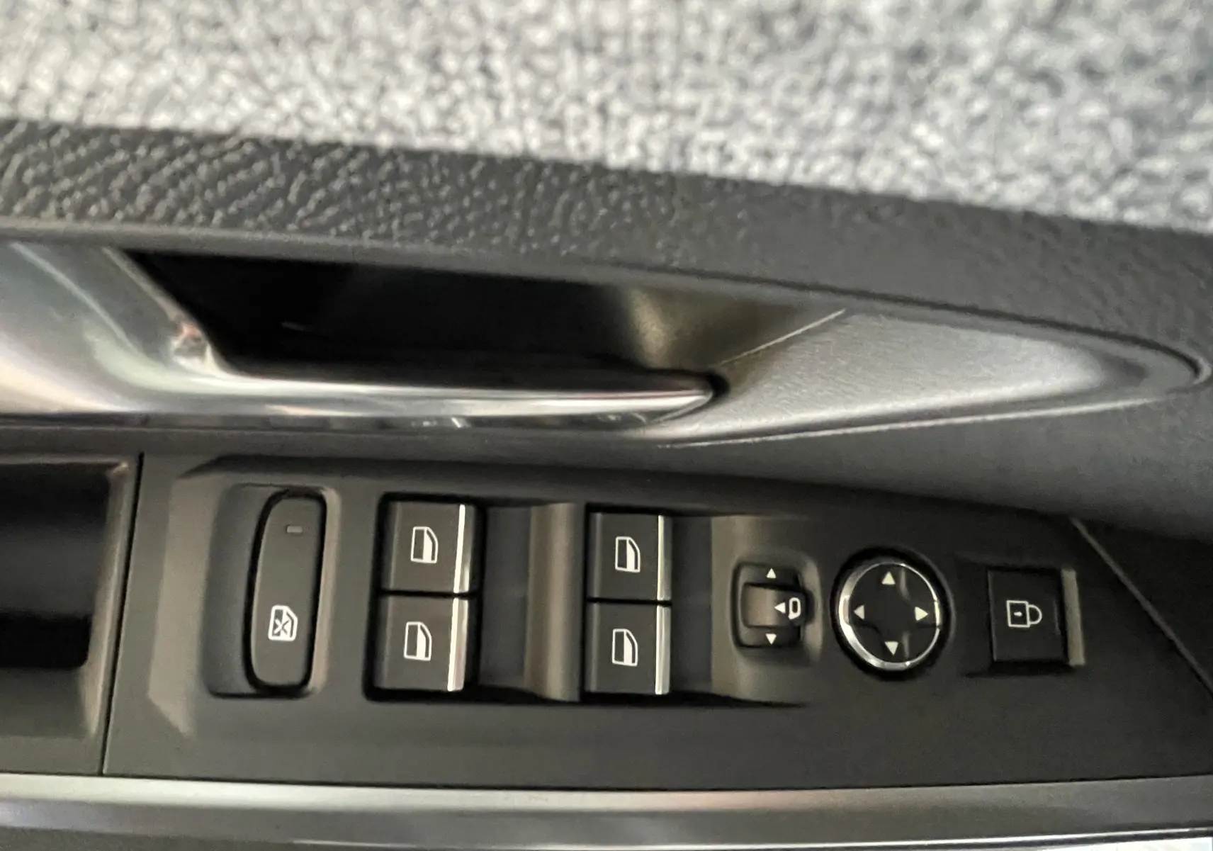 Gros plan sur la commande des vitres et rétroviseurs côté conducteur du Peugeot 3008 blanc Okenite 2026.