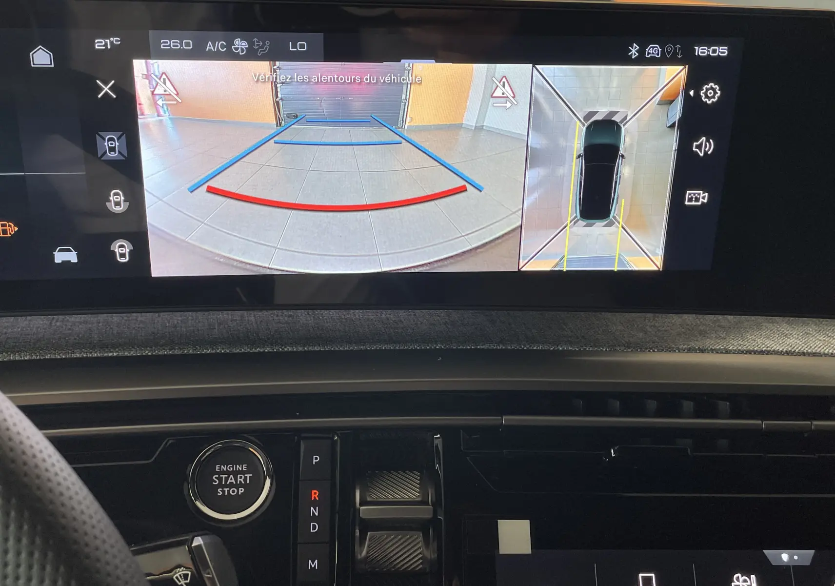 Vue intérieure du tableau de bord du Peugeot 3008 Hybrid 145 GT Exclusive 2026, écran affichant la caméra de recul et l'aide au stationnement.