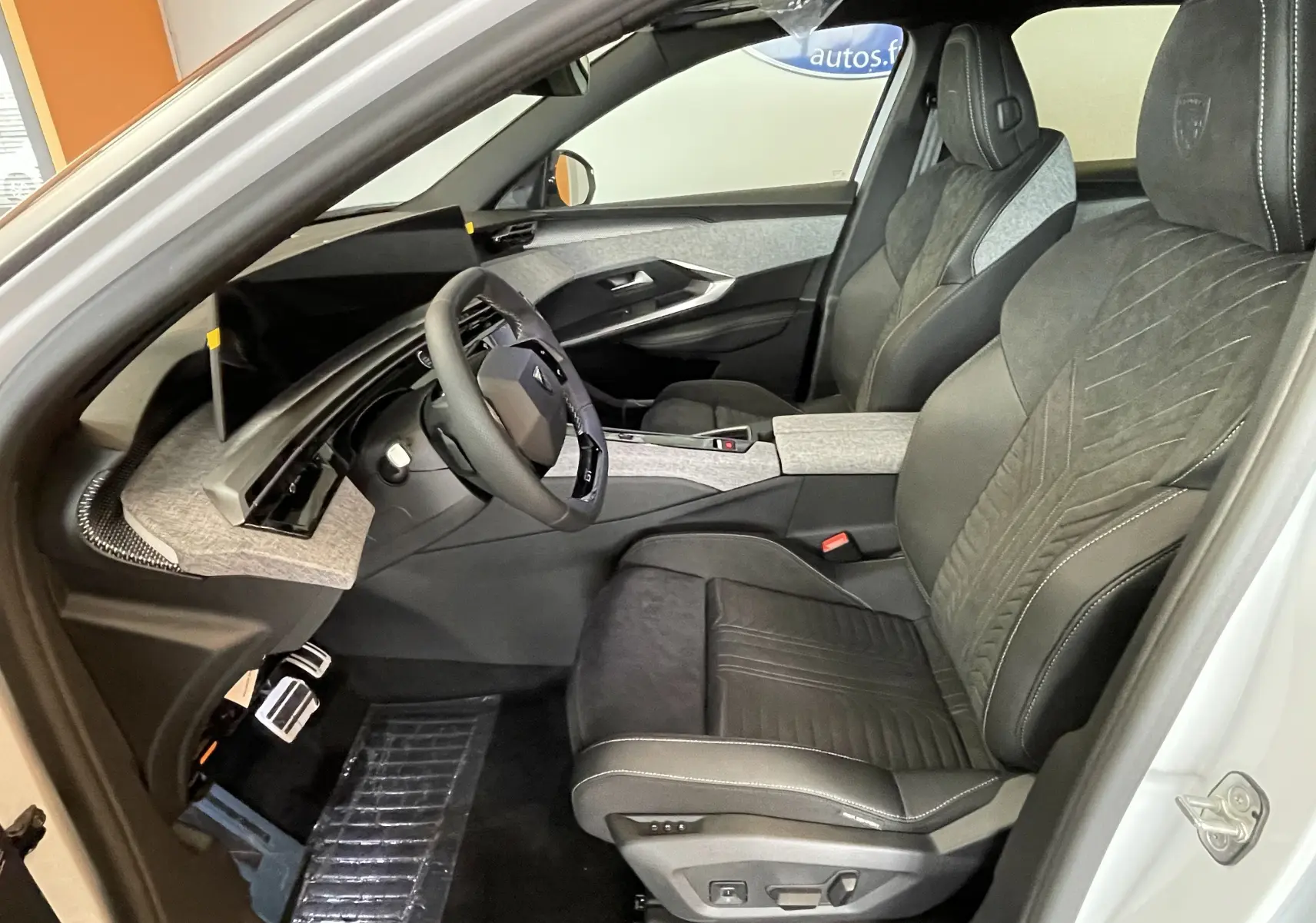 Vue intérieure côté conducteur du Peugeot 3008 Hybrid 145 GT Exclusive 2026 avec sièges Alcantara noirs et garnitures grises.