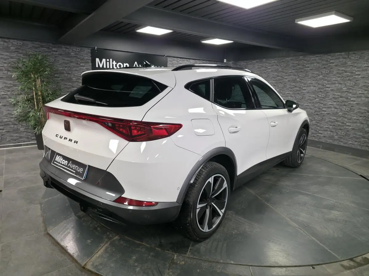 Vue 3/4 arrière droite du CUPRA Formentor blanc avec bandeau LED arrière et jantes alliage 18 pouces.