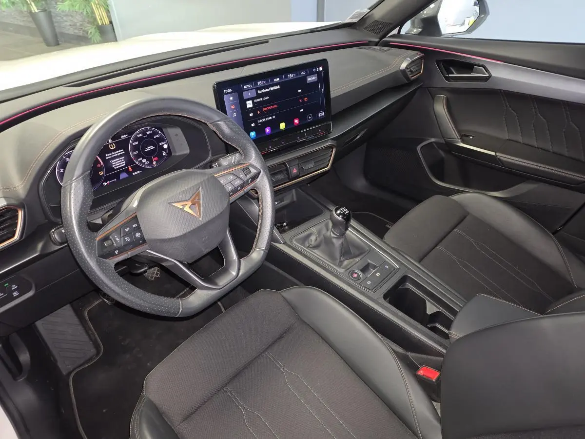Vue intérieure avant droite du CUPRA Formentor 2024 avec volant sport, écran tactile central et boîte manuelle noire.