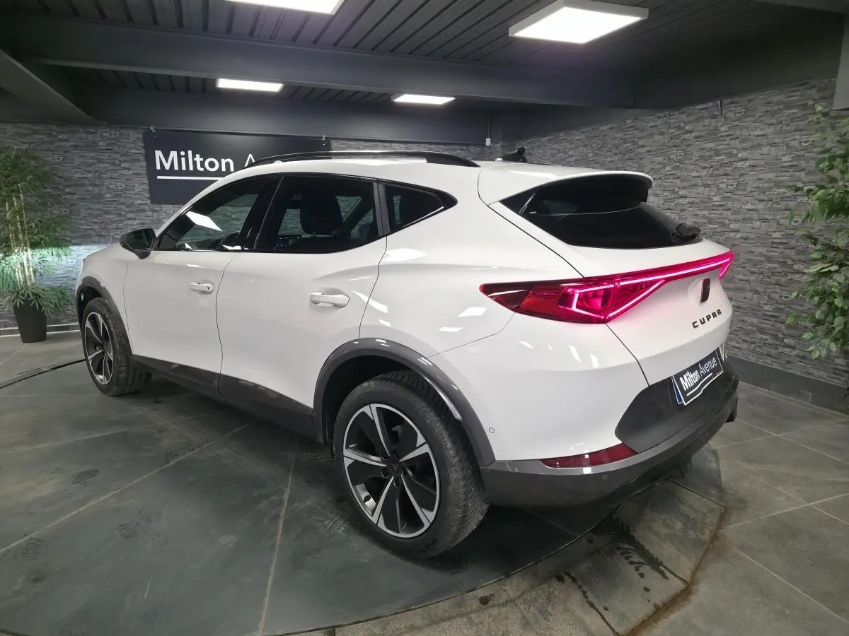 Vue 3/4 arrière droite du CUPRA Formentor blanc Nevada 2024 avec bandeau lumineux arrière et jantes alliage 18 pouces.