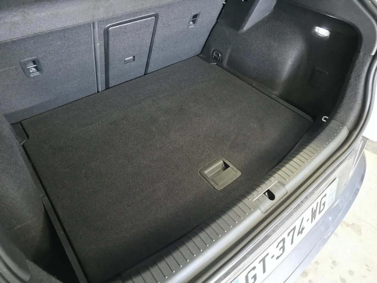 Coffre ouvert du CUPRA Formentor blanc, vue plongeante montrant le plancher plat et les finitions intérieures noires.