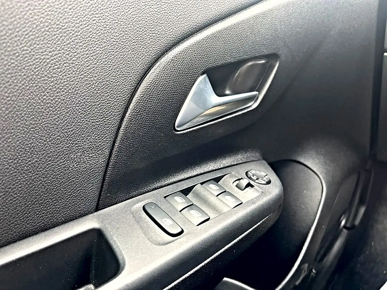 Gros plan sur la commande des vitres électriques et le verrouillage centralisé côté conducteur de l’Opel Corsa 2025.