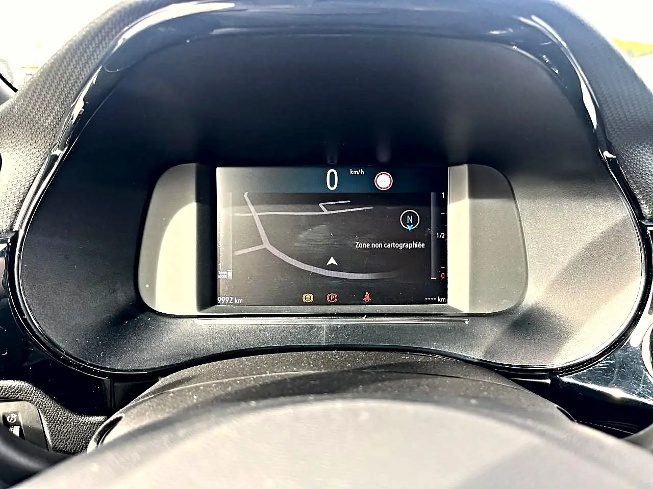 Vue rapprochée du tableau de bord numérique de l'Opel Corsa bleu 2025, affichant la navigation et 0 km/h.