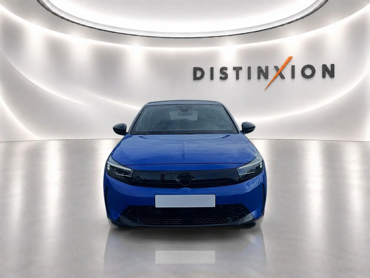 Vue frontale d'une Opel Corsa 1.2 turbo 100 gs bleu, avec calandre noire et éclairage LED, sur fond lumineux "Distinxion".