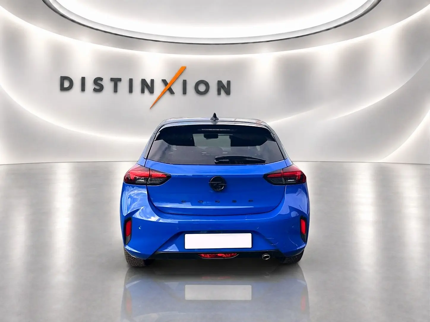 Vue arrière d'une Opel Corsa 1.2 turbo bleu vif, avec feux arrière LED et échappement à droite, en studio lumineux.
