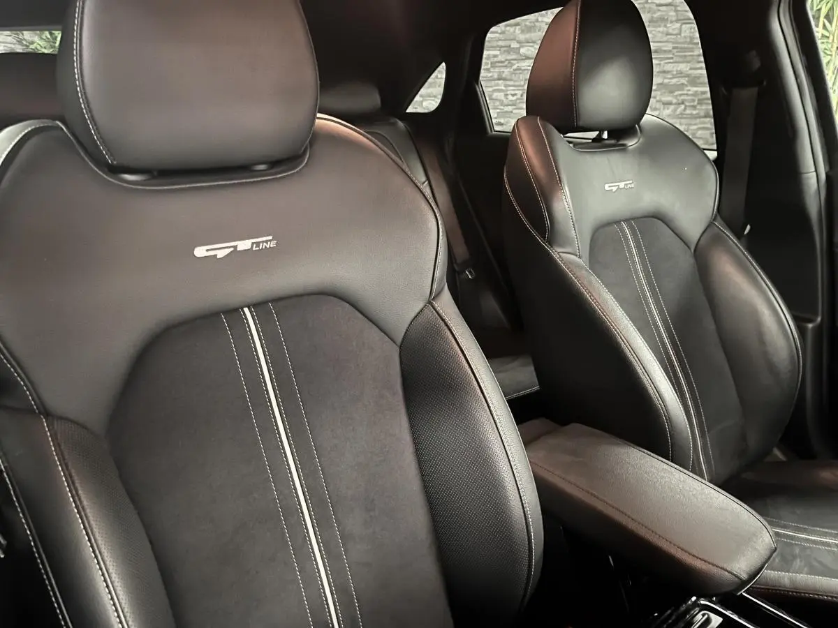 Gros plan sur les sièges avant noirs en cuir et suède avec logo GT Line brodé, intérieur d'une Kia Ceed 2023.